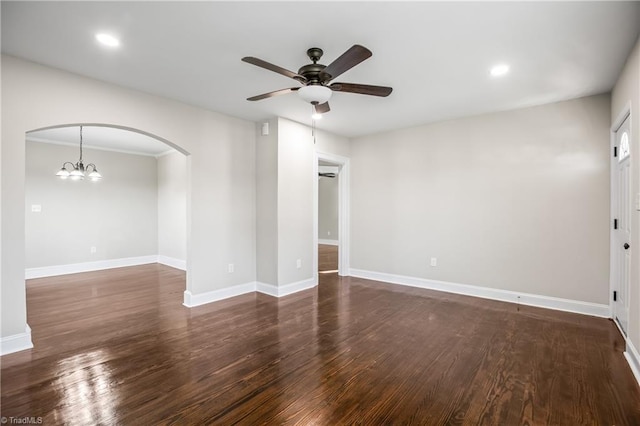 empty room with ceiling fan with notable chandelier and dark wood-type flooring