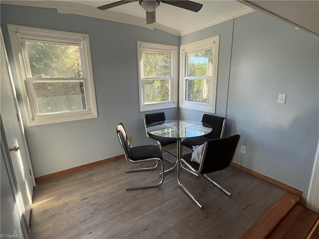 dining space featuring hardwood / wood-style flooring, vaulted ceiling, a wealth of natural light, and ornamental molding