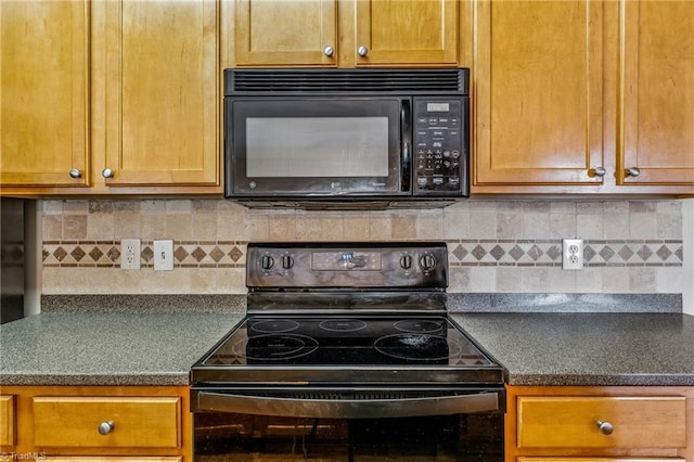 kitchen featuring decorative backsplash, black appliances, and dark countertops