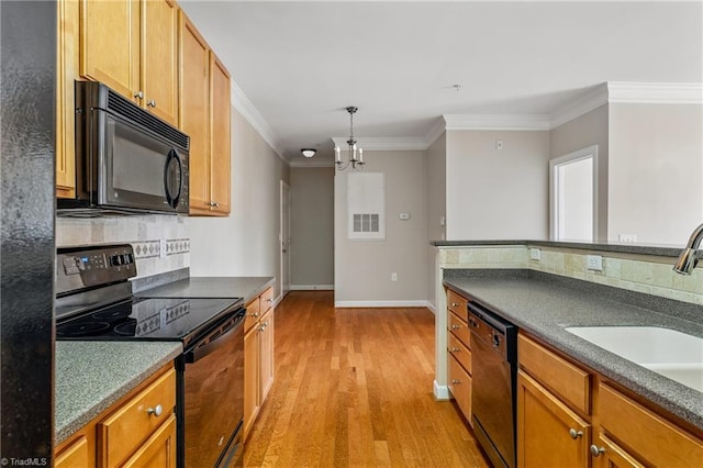 kitchen featuring ornamental molding, black appliances, light wood-style floors, dark countertops, and backsplash