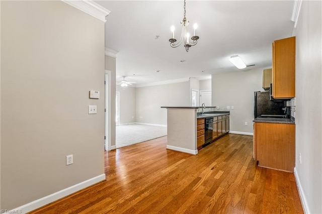 kitchen with brown cabinets, dark countertops, black appliances, and wood finished floors