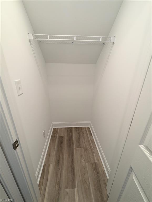 walk in closet with wood finished floors