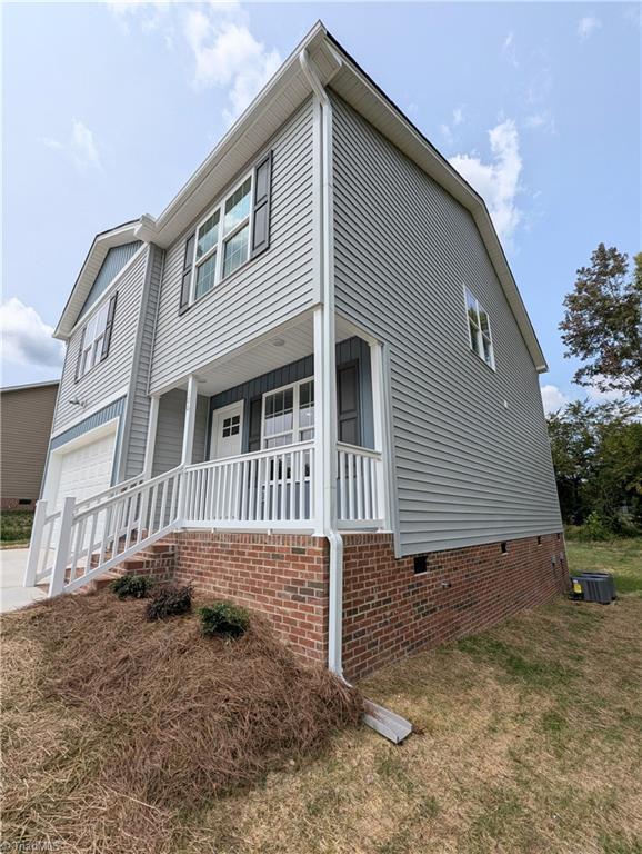 view of front of house with a garage, a porch, and a front yard