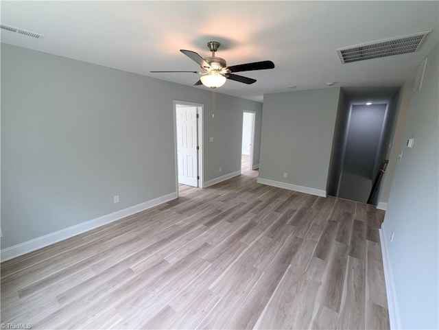 spare room featuring visible vents, baseboards, ceiling fan, and light wood finished floors