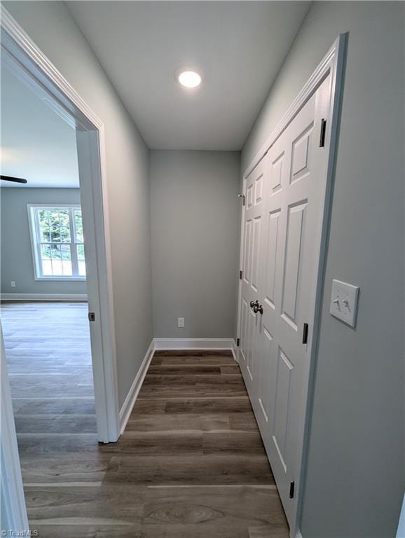 hallway with dark wood-style floors and baseboards