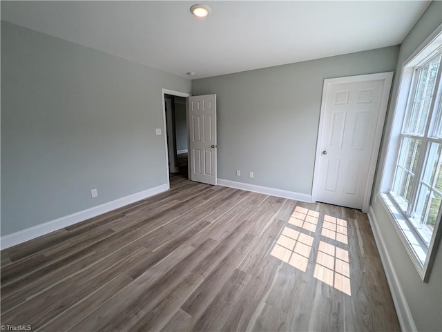 unfurnished bedroom with wood finished floors and baseboards