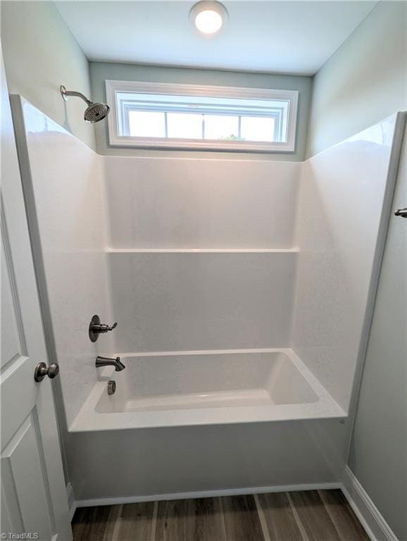 bathroom with bathtub / shower combination and wood finished floors