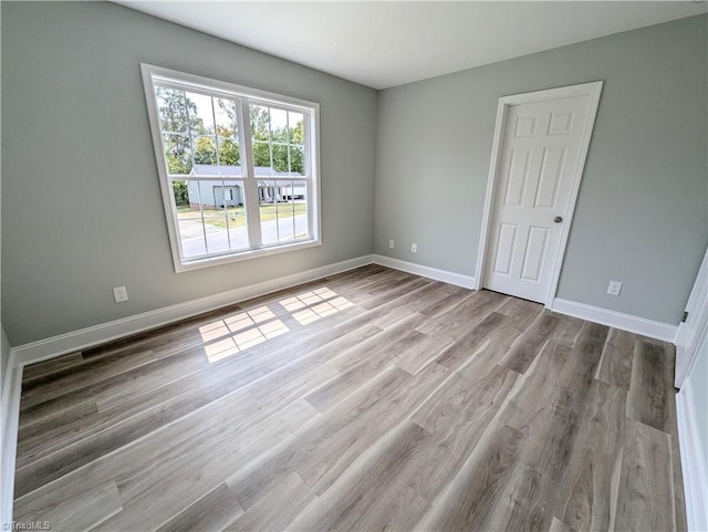 unfurnished room featuring baseboards and wood finished floors