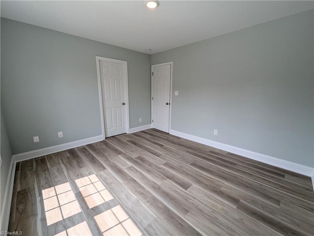 spare room featuring baseboards and wood finished floors