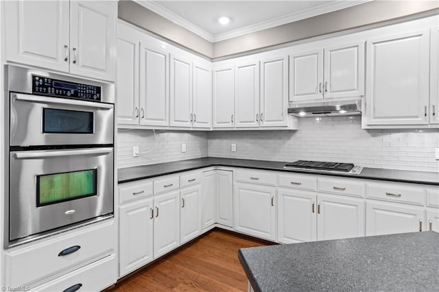 1420 Thornhill Ln, Winston-Salem, NC 27106 - kitchen with double oven, dark countertops, ornamental molding, gas stovetop, and white cabinets