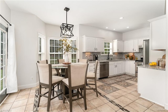 4636 Shattalon Cir, Winston-Salem, NC 27106 - kitchen with stainless steel appliances, backsplash, white cabinetry, a chandelier, and light stone counters