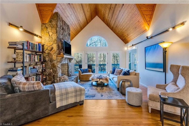 living room with french doors, a stone fireplace, light hardwood / wood-style floors, high vaulted ceiling, and wooden ceiling