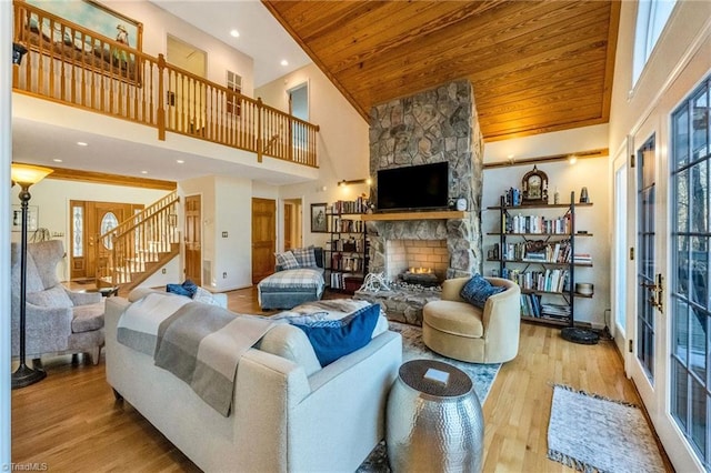 living room with high vaulted ceiling, light hardwood / wood-style flooring, wood ceiling, and a fireplace