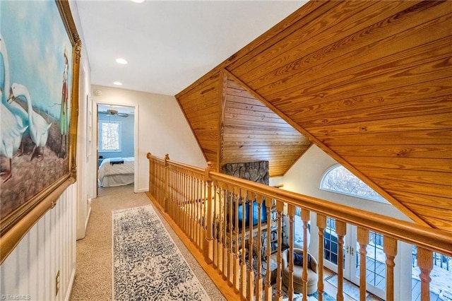 hallway featuring wood ceiling, lofted ceiling, and light carpet