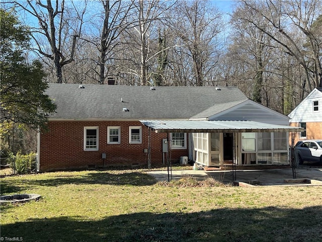 back of house featuring a patio, a sunroom, and a lawn