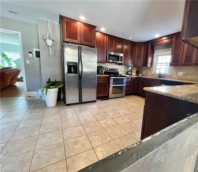 kitchen featuring stainless steel appliances, light tile patterned flooring, sink, and decorative backsplash