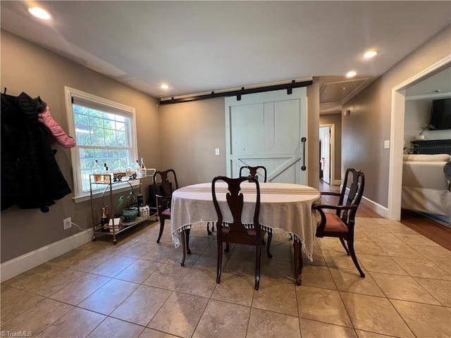 dining room with light tile patterned flooring and a barn door