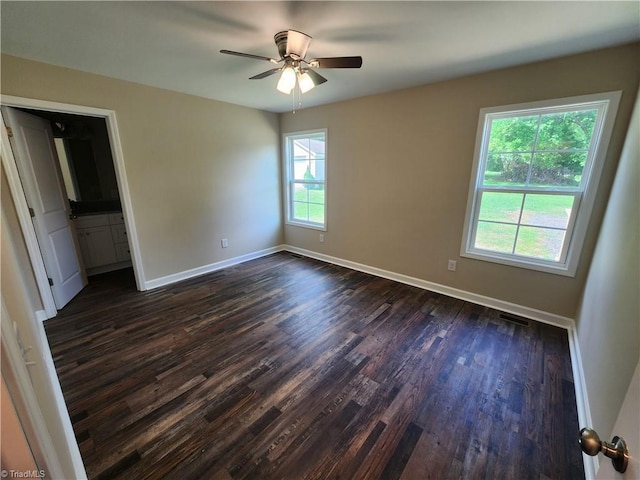 402 High Point St, Randleman, NC 27317 - unfurnished bedroom featuring dark wood finished floors, baseboards, ensuite bath, and a ceiling fan