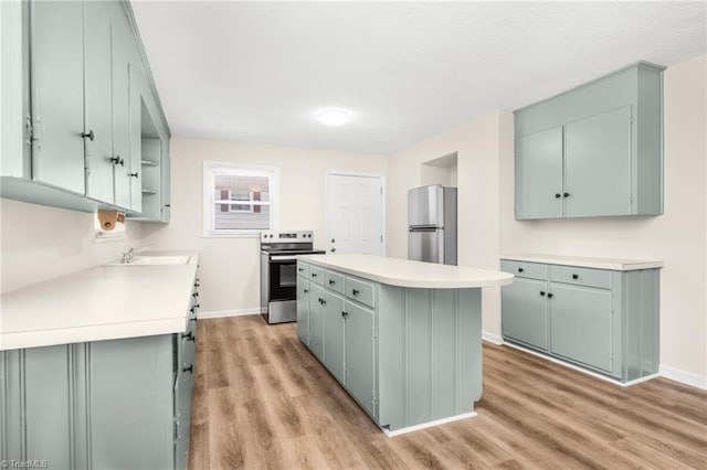 kitchen featuring sink, stainless steel appliances, a center island, and light wood-type flooring