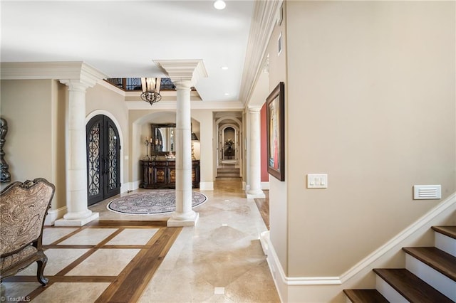 tiled entryway featuring french doors, ornamental molding, and ornate columns