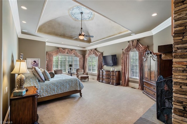 bedroom featuring ceiling fan, a raised ceiling, light carpet, and multiple windows