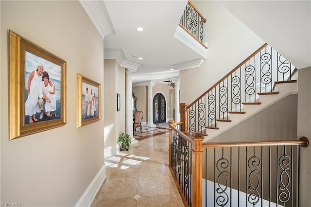 tiled foyer entrance with ornamental molding, decorative columns, and ceiling fan