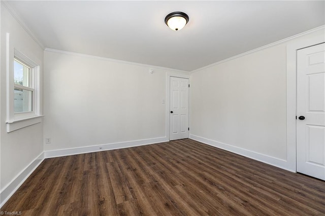 empty room with baseboards, ornamental molding, and dark wood-style flooring