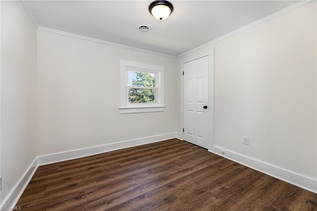 unfurnished room with visible vents, crown molding, dark wood-type flooring, and baseboards