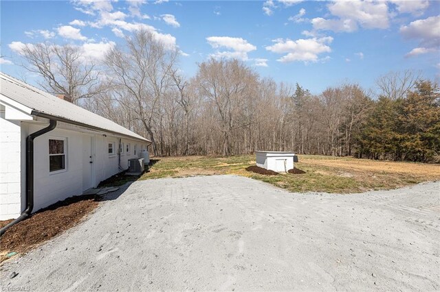 exterior space with a storage unit, central AC, and an outdoor structure