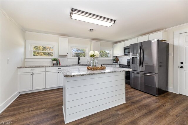 kitchen with tasteful backsplash, stainless steel microwave, dark wood finished floors, black fridge, and white cabinets