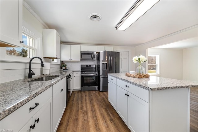 kitchen with backsplash, a center island, appliances with stainless steel finishes, dark wood-style floors, and a sink