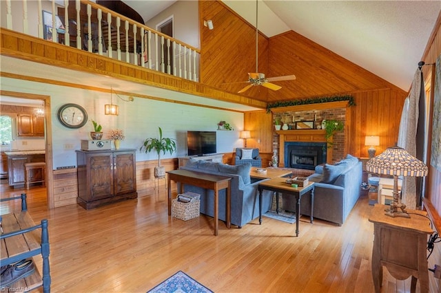 1160 Flinty Knoll Rd, Pinnacle, NC 27043 - living room with high vaulted ceiling, wooden walls, a fireplace, a ceiling fan, and wood finished floors
