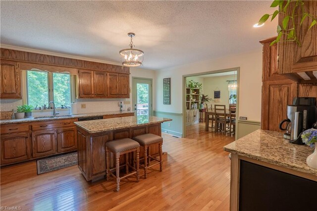 1160 Flinty Knoll Rd, Pinnacle, NC 27043 - kitchen with a sink, a center island, light wood-style flooring, brown cabinetry, and a textured ceiling
