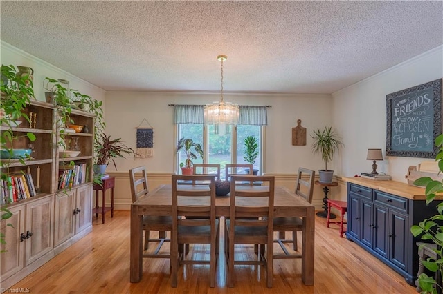 1160 Flinty Knoll Rd, Pinnacle, NC 27043 - dining room with ornamental molding, a textured ceiling, a chandelier, light wood-style floors, and wainscoting