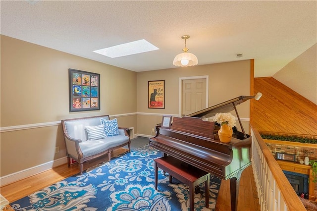 1160 Flinty Knoll Rd, Pinnacle, NC 27043 - sitting room featuring a skylight, baseboards, wood finished floors, and a textured ceiling