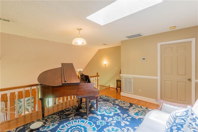 1160 Flinty Knoll Rd, Pinnacle, NC 27043 - sitting room with a skylight, an upstairs landing, wood finished floors, vaulted ceiling, and baseboards