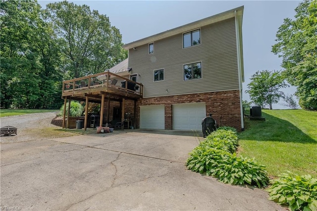 1160 Flinty Knoll Rd, Pinnacle, NC 27043 - back of property with an attached garage, concrete driveway, a lawn, a deck, and brick siding