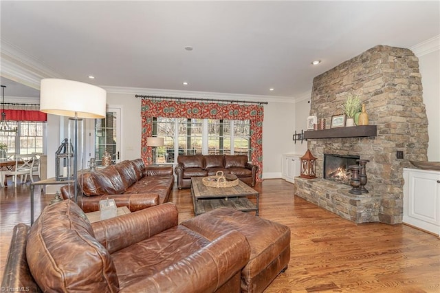 living room featuring a fireplace, wood-type flooring, and ornamental molding