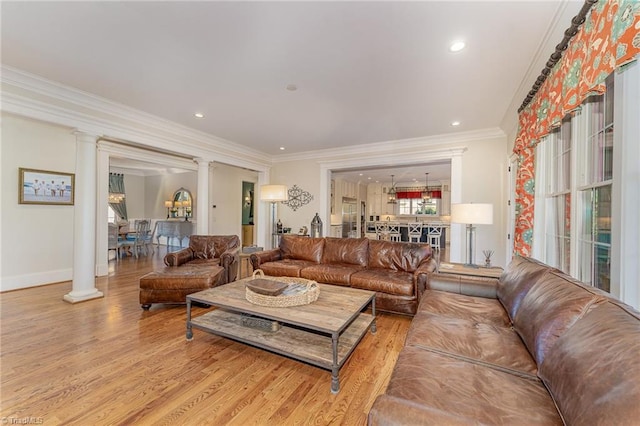 living room featuring hardwood / wood-style floors, crown molding, and decorative columns