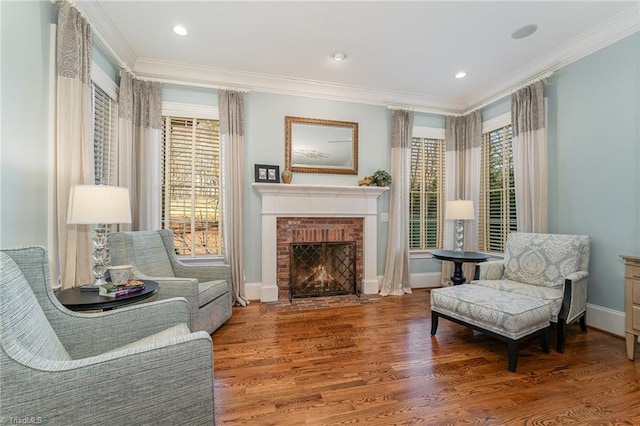 living area with hardwood / wood-style floors, a fireplace, and ornamental molding