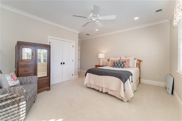 carpeted bedroom with ceiling fan, ornamental molding, and a closet