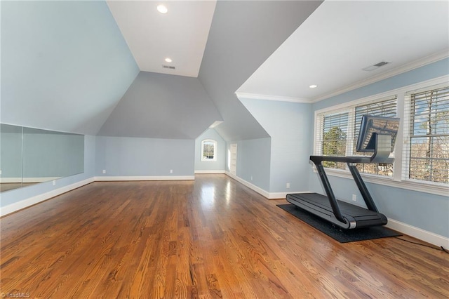 workout area featuring vaulted ceiling, ornamental molding, and hardwood / wood-style floors