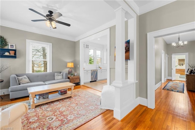 living room with light hardwood / wood-style flooring, crown molding, and a wealth of natural light