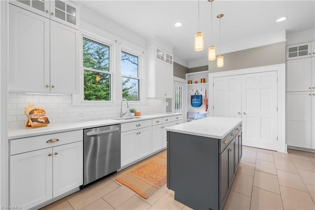 kitchen with a kitchen island, pendant lighting, white cabinetry, sink, and stainless steel dishwasher