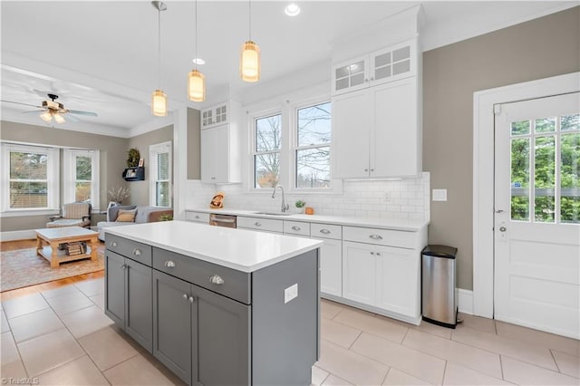 kitchen with hanging light fixtures, gray cabinetry, white cabinets, and decorative backsplash