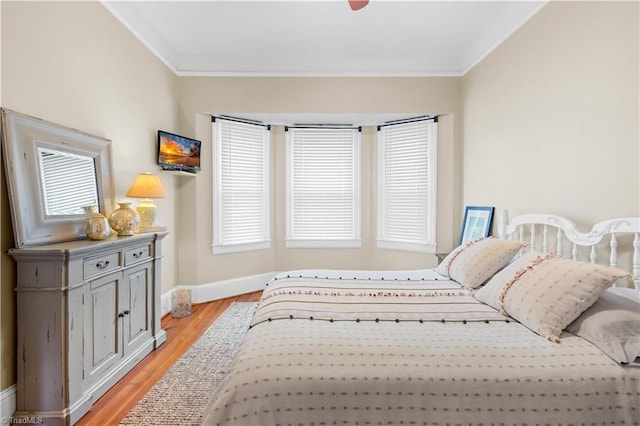 bedroom with crown molding, light hardwood / wood-style floors, and ceiling fan