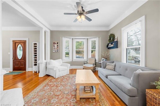 living room featuring hardwood / wood-style flooring, decorative columns, and ceiling fan