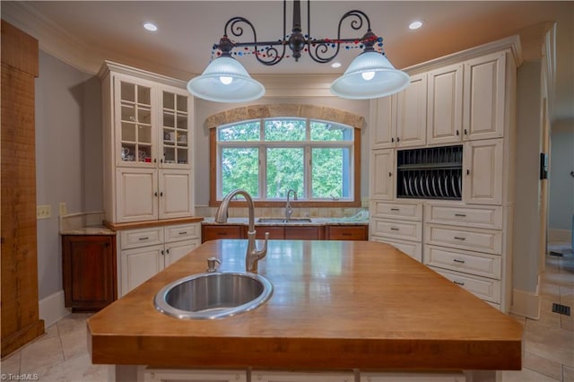 kitchen with white cabinets, a kitchen island with sink, and sink