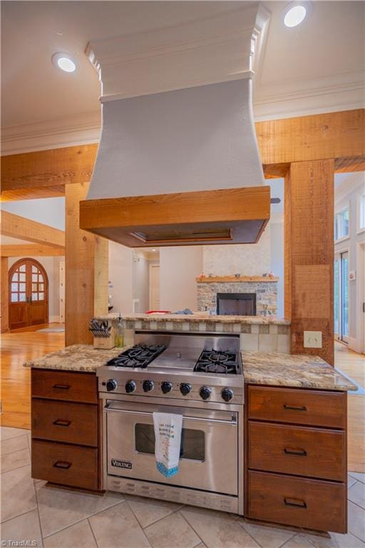 kitchen featuring ornamental molding, kitchen peninsula, premium stove, and custom range hood