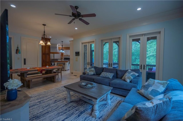 living room featuring ceiling fan with notable chandelier, crown molding, french doors, and light tile patterned floors